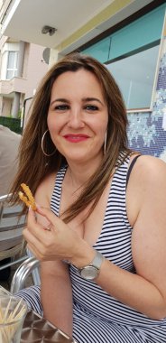 Terasta dövülmüş mürekkep balığı yiyen güzel bir kadın.