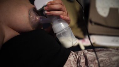 Bebeğini emzirmek için göğüslerinden süt çıkaran bir kadın.