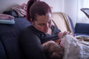 Genç bir anne bebeğini emziriyor.