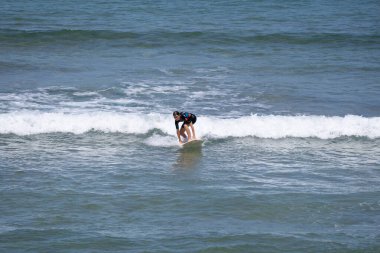 Guipuzcoa, Zarautz, İspanya - 09 Temmuz 2022: Zarautz sahillerinde sörfçü. Sörfçü, Bask Ülkesi kıyılarında güzel bir dalganın gelişini bekliyor.
