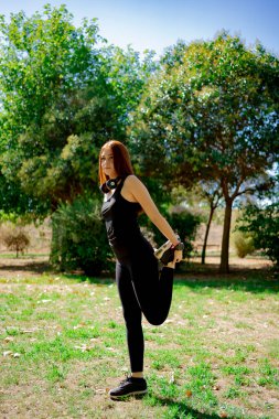 Portrait of fit and sporty young woman doing stretching in public park. stock photography