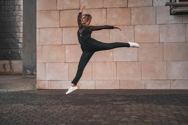 若い女の子は通りで体操ジャンプをする 都市コンテンポラリーダンスのコンセプト ストックフォト ロイヤリティフリーのストック画像