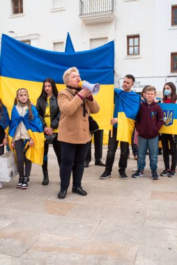 Estepona, Endülüs, İspanya - Mart. 05, 2022. Protestocular, Rus saldırısına karşı Ukrayna 'yı desteklemek için toplandılar. Savaş karşıtı gösteri. Kadın hoparlörle hoparlör yapıyor..