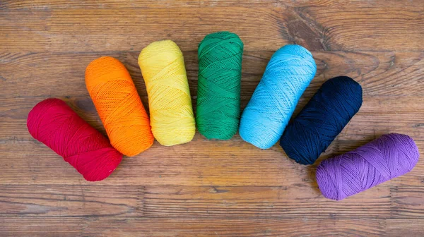 Sieben Garnknäuel Regenbogenfarben Reihen Sich Regenbogenform Auf Einer Holzoberfläche Sticken — Stockfoto