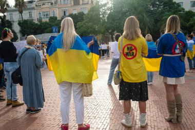 Malaga, Endülüs, İspanya - 22 Ekim 2022. Arkadan Ukrayna sembolikleri ve savaş karşıtı tabelaları olan kadınlar..