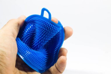 Eldeki tabakları ovalamak için bir araç. İzole edilmiş beyaz arkaplanda mavi.