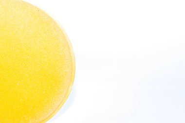 İzole edilmiş beyaz arka planda sarı yarı daire süngeri.