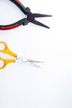 İzole edilmiş beyaz arka planda sarı pense ve makas. biçim denklemi.