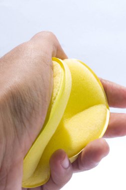 Bulaşık süngeri izole edilmiş beyaz bir arka tarafta tutuyordu..