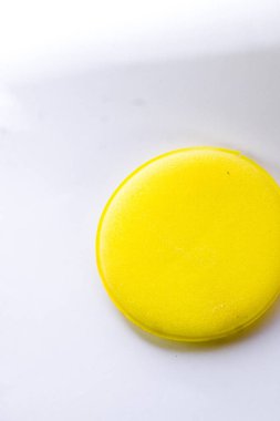 İzole edilmiş beyaz arka planda sarı bulaşık süngeri.