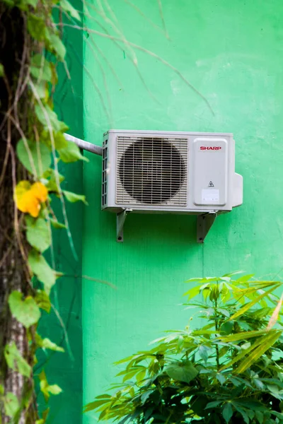 Duvarda açık havada yeşil renkli ac makinesi var. Güney Kalimantan, Endonezya. 25 Aralık 2021. 