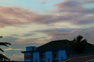 silhouette of a building with a soft colored sky.