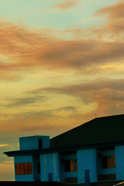 silhouette of a building with a yellow-orange gradation sky.