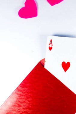 The ace of hearts is taken out of the red envelope on an isolated white background. 