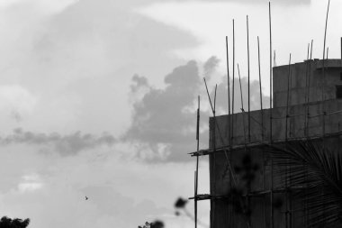 Bulutlu gökyüzü arkaplanlı bina bitmek üzere. Hayat alıntıları, din, tebrik kartları ve dekorasyonlar için yer kopyalamak. siyah ve beyaz fotoğrafçılık