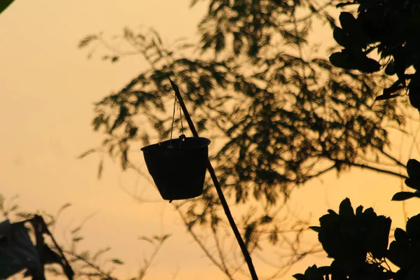 Uzun bir bambunun ucunda bir kova silueti. Hayat alıntıları, din ve duvar dekorasyonları için boşluk kopyala.