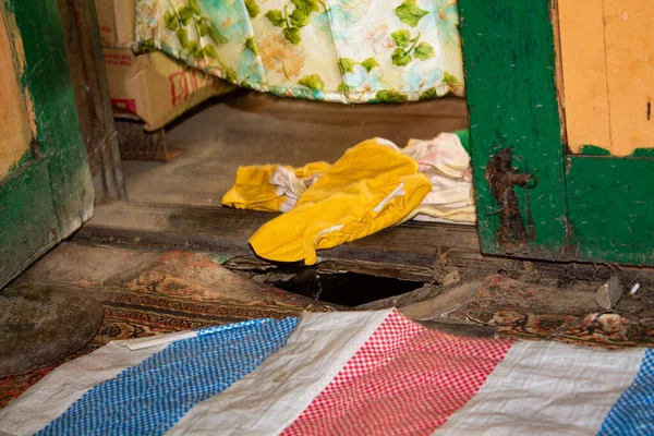 Evin zemininde yıpranmış bir delik var çünkü yıpranmış. Nehir kenarında yaşam koşulları.