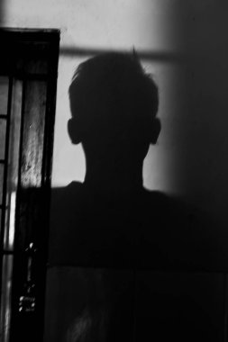 Duvarda genç bir adamın gölgesi. siyah ve beyaz fotoğrafçılık. 