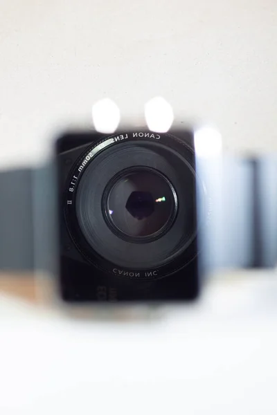 İzole edilmiş beyaz arka plandaki saat camında Canon merceği yansıması. Fotoğraf, video, kamera, lens ve ürünler için kopyalama alanı. Güney Kalimantan, Endonezya. 19 Mart 2014.