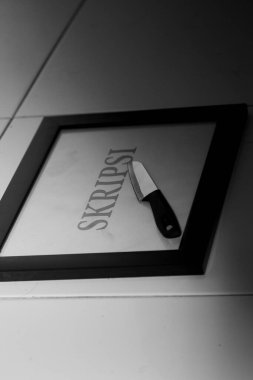 Tez ve bıçaklar fayansların üzerinde yatıyor. Siyah beyaz fotoğrafçılık. Eğitim, mezuniyet, son proje ve tez için kopyalama alanı.