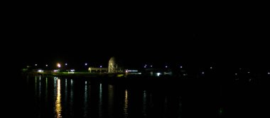 Suyun üzerinde güzel bir ışık demeti. Sanayi şehri, fabrika yerleşimi. sanayi, maden, şehir ve bölge yaşamı için kopyalama alanı.