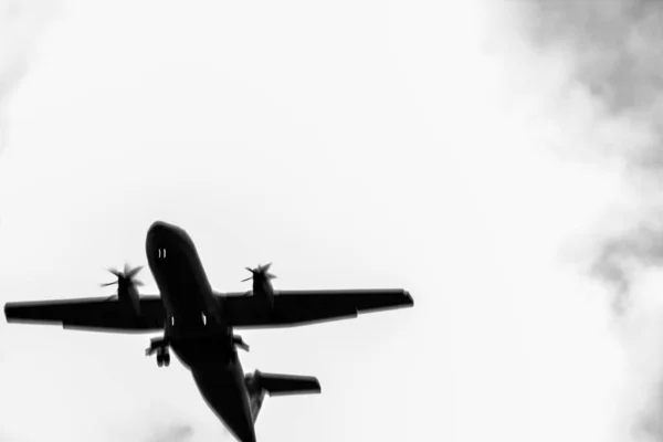 Beyaz bir gökyüzü arka planında uçak silueti. Havaalanından kalkan yolcu uçağının silüeti. havacılık, hava taşımacılığı ve havaalanları için kopyalama alanı.