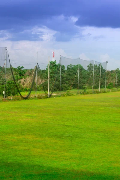 Yeşil çimenli golf sahasında ağlar. Saha kenarına. Topun sahadan ayrılmasını engellemek için. Çevre, yeşillik, güzellik, spor ve dış mekan için kopyalama alanı.