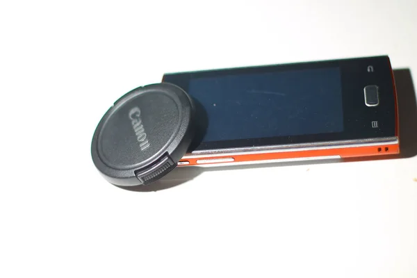 Schwarzer Canon Objektivdeckel Und Smartphone Auf Isoliertem Weißem Hintergrund Südkalimantan — Stockfoto