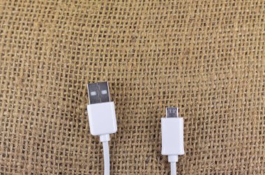 İzole edilmiş bir arka planda mikro usb ve usb beyaz usb usb kablosu. Estetik fotoğrafçılık. Ürünler, cep telefonu aksesuarları, güç, teknoloji ve bağlantılar için kopyalama alanı.