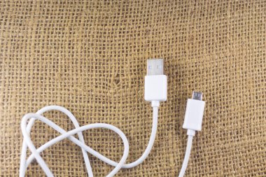 İzole edilmiş bir arka planda karmaşık beyaz USB kablosu. Estetik fotoğrafçılık. Ürünler, cep telefonu aksesuarları, güç, teknoloji ve bağlantılar için kopyalama alanı.