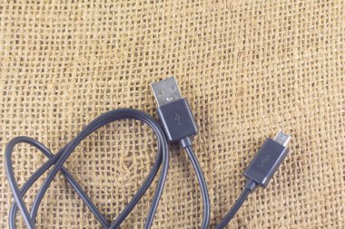 İzole edilmiş bir arka planda siyah mikro USB kablosu. Estetik fotoğrafçılık. Ürünler, cep telefonu aksesuarları, güç, teknoloji ve bağlantılar için kopyalama alanı.