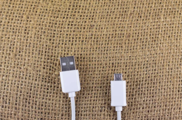 İzole edilmiş bir arka planda mikro usb ve usb beyaz usb usb kablosu. Estetik fotoğrafçılık. Ürünler, cep telefonu aksesuarları, güç, teknoloji ve bağlantılar için kopyalama alanı.
