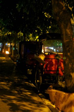 Rickshaw yolcu bekliyor. Yoldaki yaşam için kopyalama alanı, yoldaki geçim kaynakları, yoldaki faaliyetler ve trafik. Geleneksel ulaşım araçları Endonezya 'da 