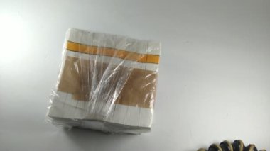 Elle sarılmış sigara için bir deste kağıt. Renklendirme yok. Tarafsız video. 4K video görüntüleri. 
