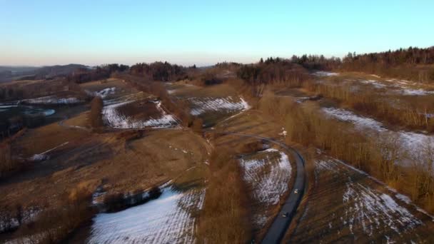 冬は畑や森が広がる田園風景の中 空の道を一緒に走る車 — ストック動画
