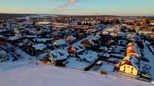 冬に雪の厚い白い層で覆われた町の風光明媚な景色を示す空中ドローンビデオ 雪が日の出の風景を覆い — ストック動画