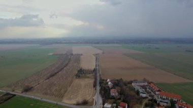 Kırsal kesimde, Svat Kopeek yakınlarında küçük bir köy. Olomouc şehrinin ufuk çizgisine kadar uzanan tarlalar arasında dramatik bir günbatımı ve bulutlar var.