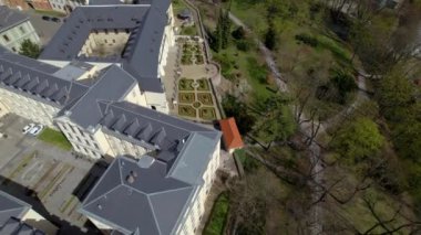 Olomouc şehrindeki Palacky Üniversitesi 'nin manikürlü üniversite bahçeleri güneşli bir bahar gününde tarihi binaların bulunduğu bir parkta - hava aracı atışı, Çek Cumhuriyeti