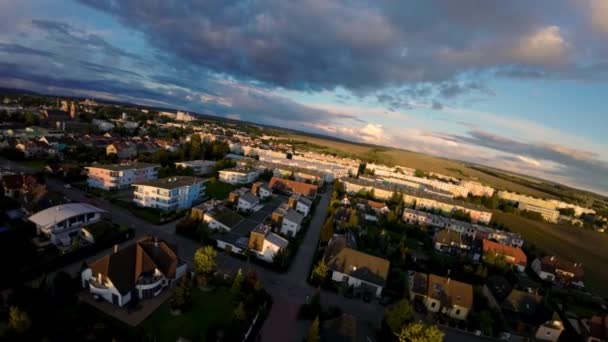 Letecký pohled na ulici obklopenou domy s mladými rodinami v nové čtvrti města Svitavy v České republice. Romantický pohled na dron při západu slunce