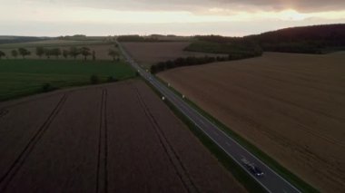 Kırsal asfalt yolda güzel manzaralı arabaların hava manzarası. 4K görüntüler. Otobanda drone klipleri. Tarım Tarlaları.