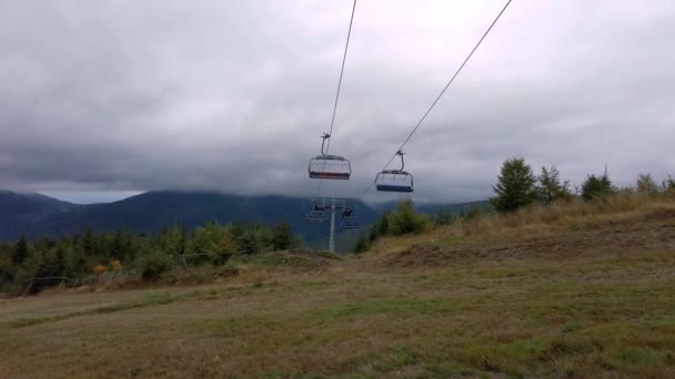 多云的一天 低角度拍摄的空电梯电缆 供人们沿山脉运送 — 图库视频影像