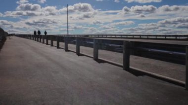 Yeni çitler, mavi gökyüzü, yol boyunca yürüyen işçiler.