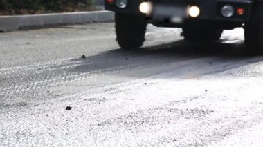 Bir araba siyah zift yolu boyunca gidiyor, siyah tekerlekler.