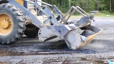 # Sarı traktör ve kova # # Gri taş moloz yığınını dümdüz ediyor #