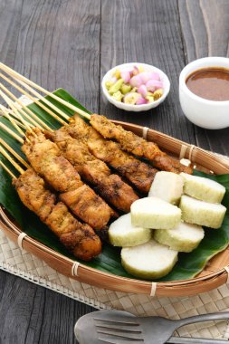 Lontong ve fıstık soslu tavuk satay (sate ayam). Endonezya 'nın popüler sokak yemeklerinden biri. Seçici odak.