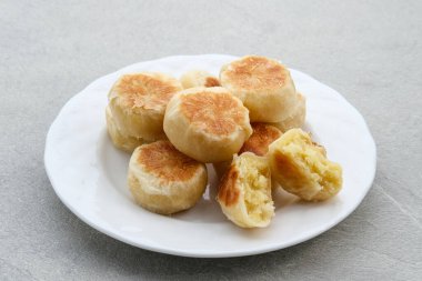 Bakpia, Bakpia Pathok, yeşil fasulye, peynir ve şeker karışımından yapılan tipik bir Yogjakarta yiyeceğidir. Seçici odak resmi. Gri arkaplanda beyaz plaka ile servis edilir.