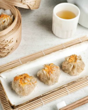 Beyaz arka planda beyaz tabakta servis edilen buğulanmış hamur köftesi. Seçici odak resmi, kapat.