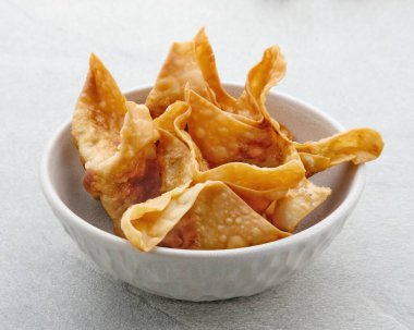 Pangsit, Pangsit Goreng, Lezzetli Pangsit Ayam Goreng (Tavuk Kızartması), Endonezya Geleneksel Yemekleri un ve tavuktan yapılır. Soslu beyaz kasede servis ediliyor. Seçici odak ve resmi kapat.