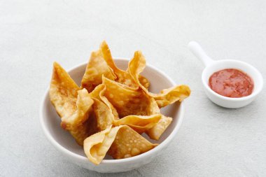 Pangsit, Pangsit Goreng, Lezzetli Pangsit Ayam Goreng (Tavuk Kızartması), Endonezya Geleneksel Yemekleri un ve tavuktan yapılır. Soslu beyaz kasede servis ediliyor. Seçici odak ve resmi kapat.