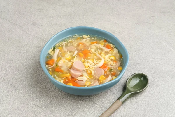 Corn cream soup with chicken, sausage, egg, carrots and cornstarch, savory and delicious. Served in bowl, copy space.